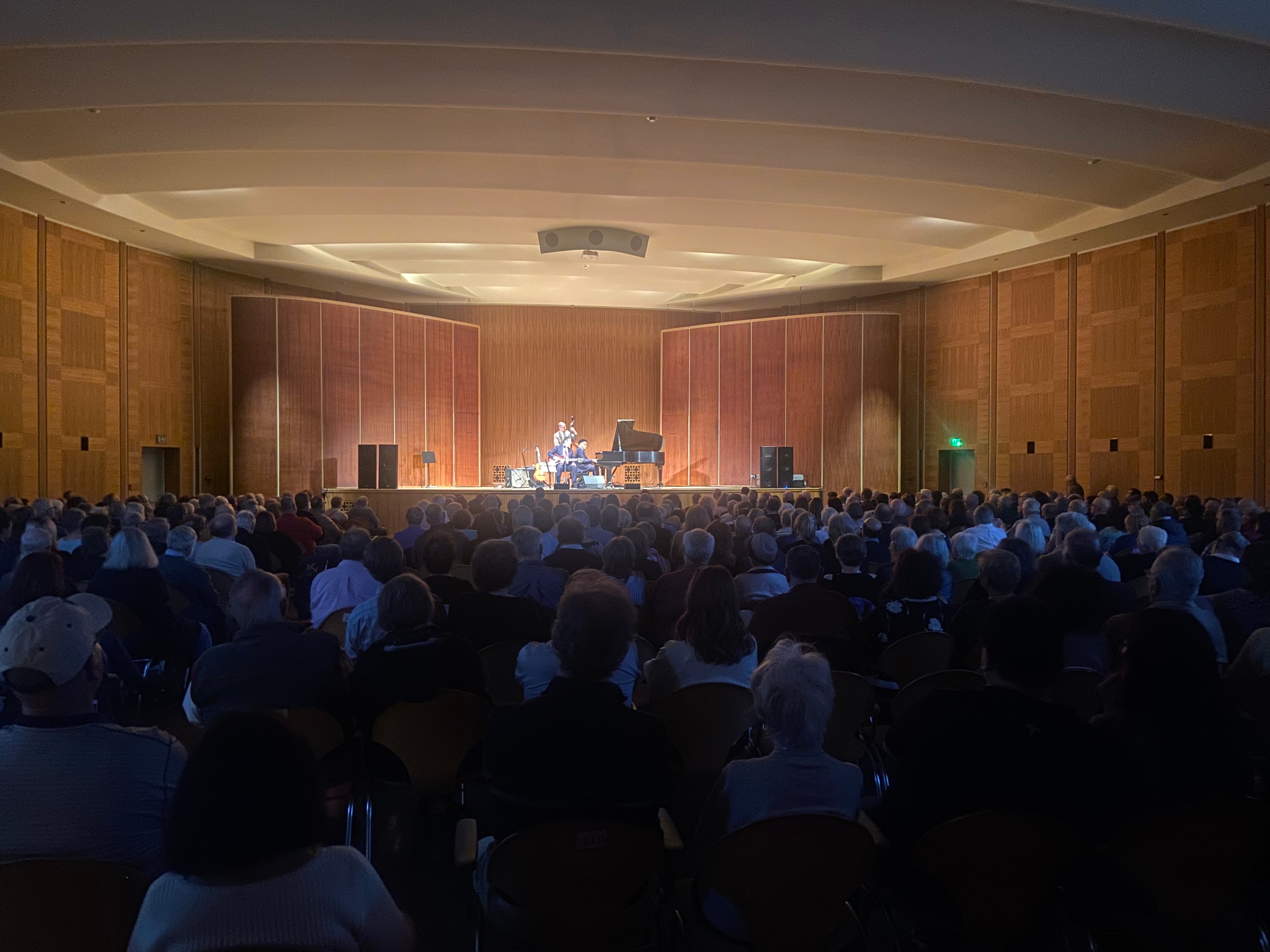 A full audience facing the stage in the Mary Seaton Room